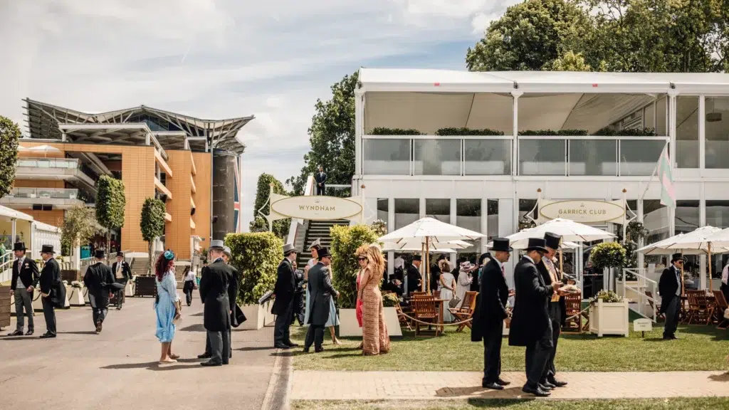 Royal Ascot Wyndham Restaurant – Elegant guests in formal attire, including top hats and dresses, enjoying a luxurious outdoor hospitality area at the prestigious Royal Ascot horse racing event