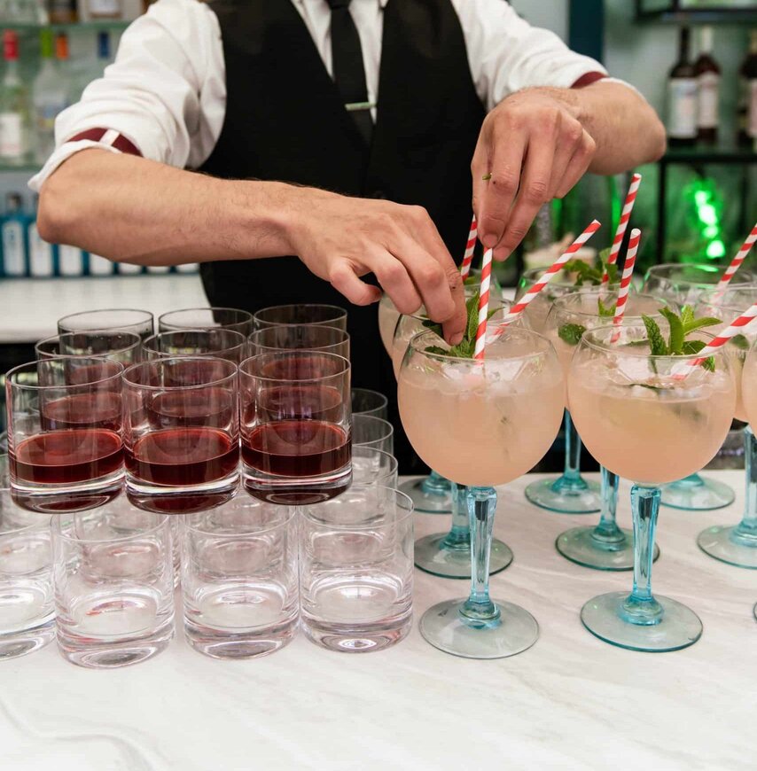 Bartender crafting cocktails at Wimbledon’s The Gallery, featuring elegant drinks with fresh garnishes and a stylish bar setting