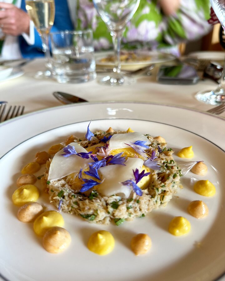 Gourmet crab dish at Wimbledon’s Renshaw Restaurant, elegantly plated with edible flowers, creamy sauce, and fine dining presentation