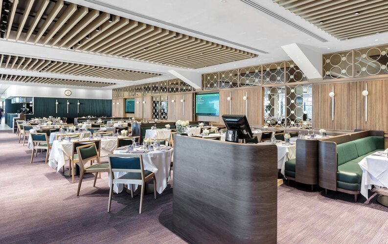 Wimbledon Courtside Restaurant featuring elegant table settings, modern decor, and a refined dining atmosphere with a view of live match updates