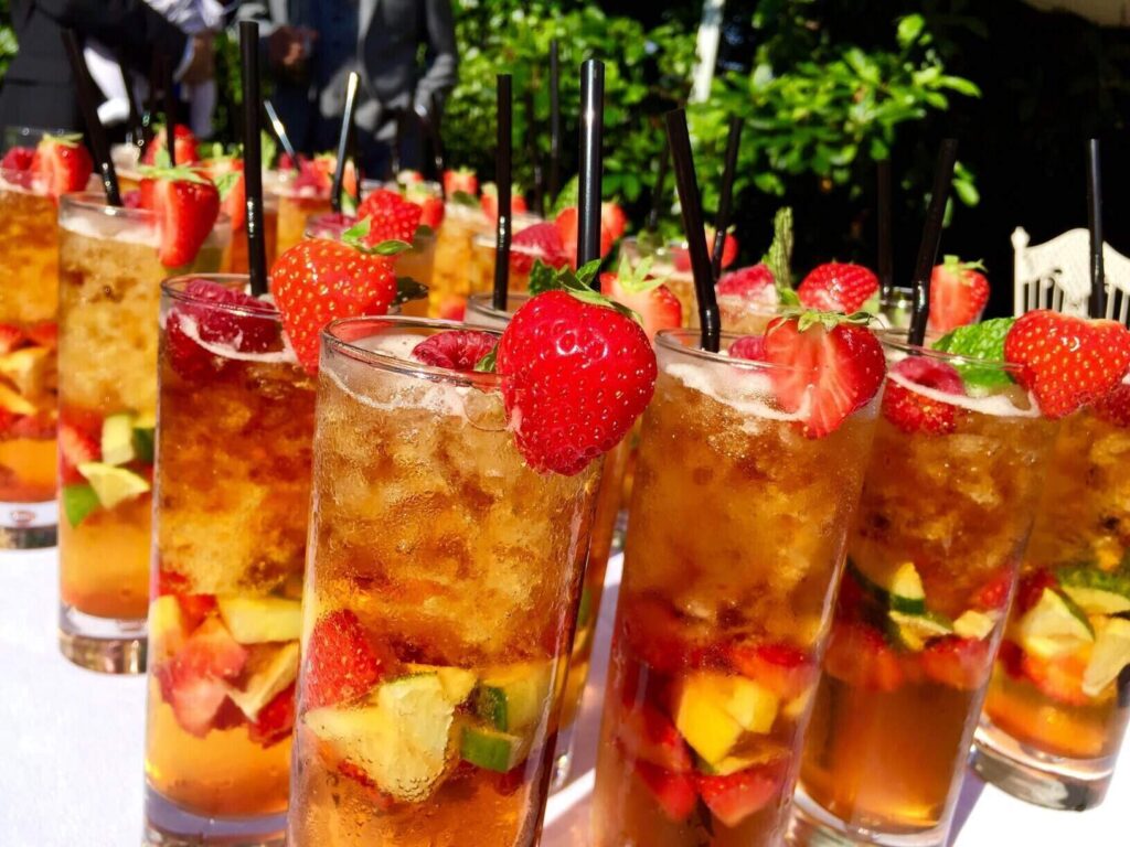 Refreshing Pimm’s cocktails served at Royal Ascot, garnished with fresh strawberries, mint, and citrus fruits, perfect for a summer reception