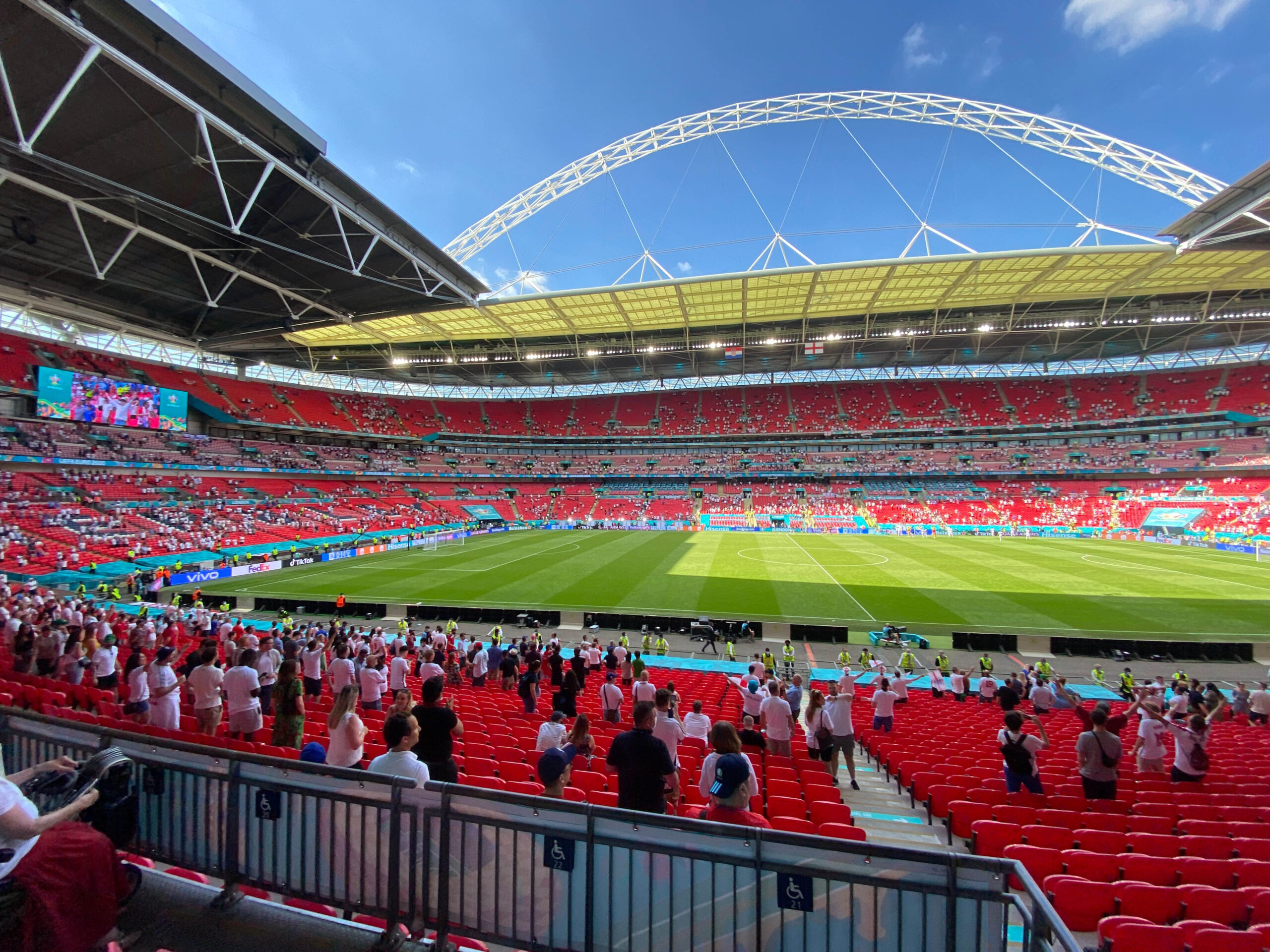 Fans gather inside Wembley Stadium in London for an England football match on a sunny day
