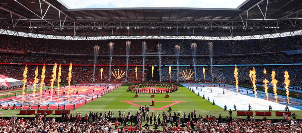 FA Cup Final 2025 at Wembley Stadium, featuring a spectacular pre-match show with fireworks, team banners, and packed stands of red and blue supporters.