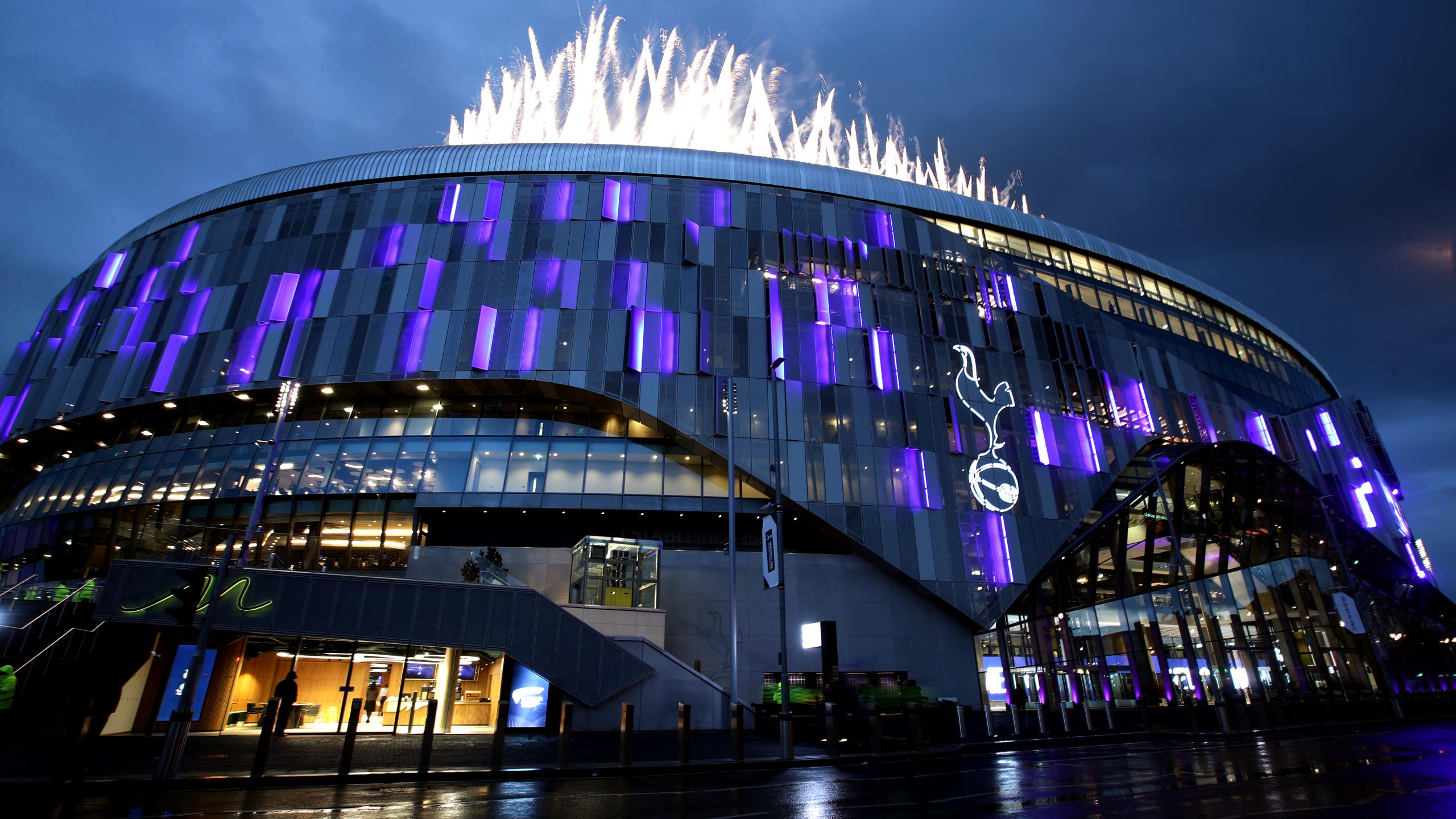 The iconic Tottenham Hotspur Stadium at night, illuminated in purple and with fireworks overhead, showcasing a world-class venue for premier sports and corporate hospitality in London.