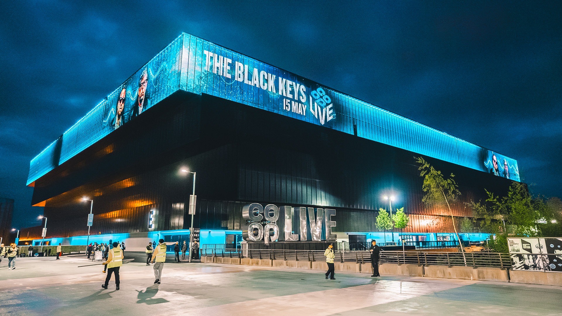 The Co-op Live arena in Manchester at night, with the digital screen promoting The Black Keys concert, showcasing a premier live music event ideal for corporate hospitality.