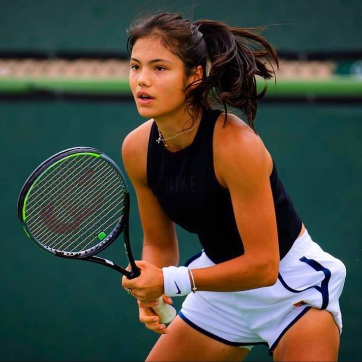 Emma Raducanu holding tennis racket ready to play